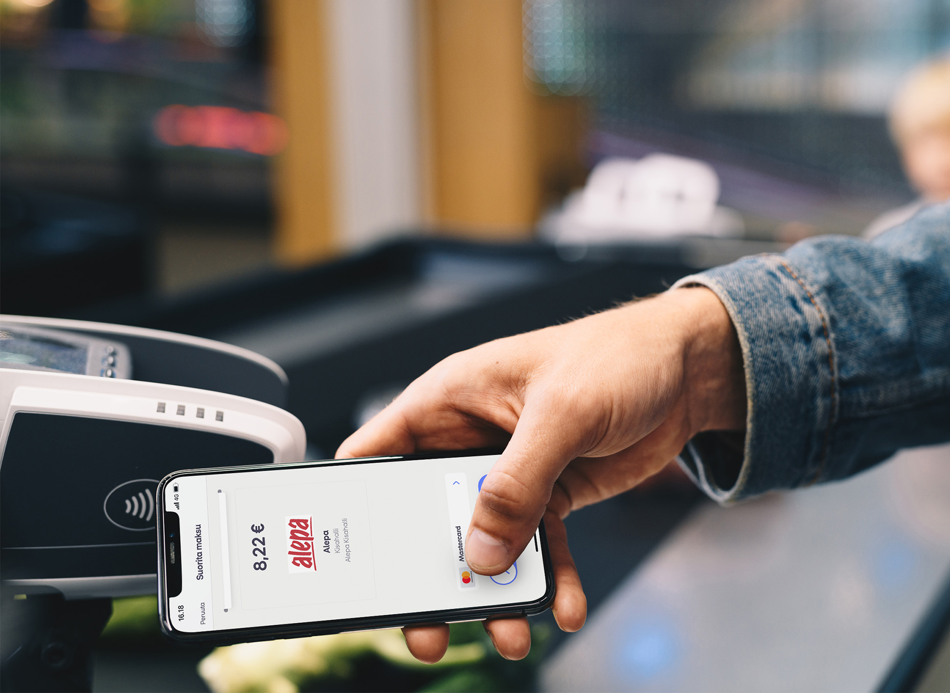 Henkilö maksamassa MobilePaylla maksupäättellä.