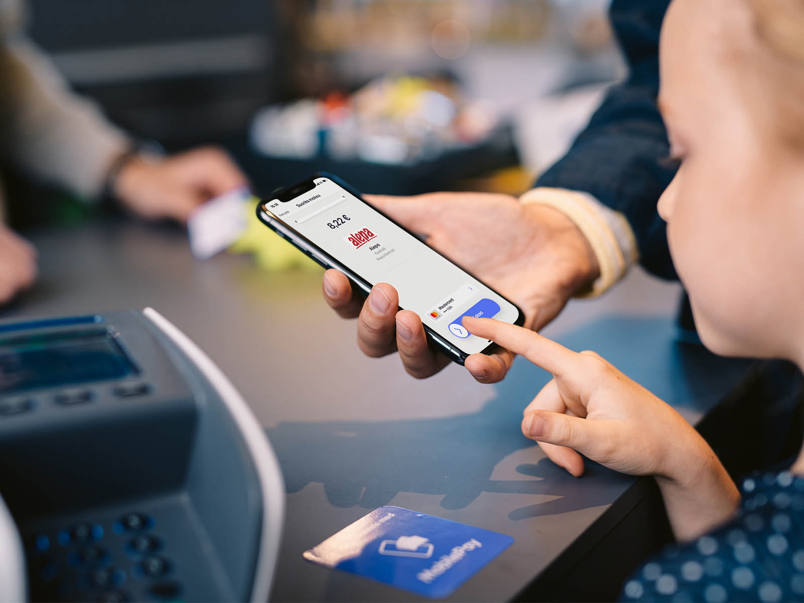 Mobiilimaksamisen ABC - kaikki mitä yrityksen tulee tietää mobiilimaksamisesta. Lapsi tekee maksua kassalla MobilePaylla.