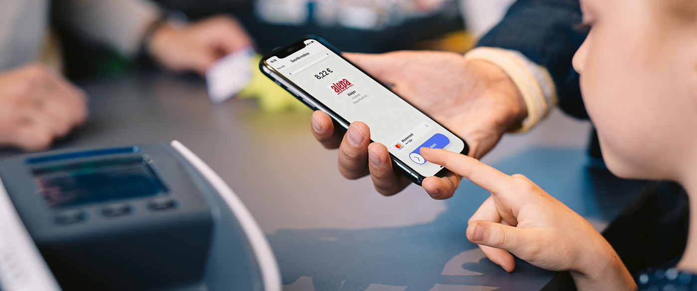 Lapsi ja mies ruokakaupan kassalla maksamassa ostoksia MobilePaylla
