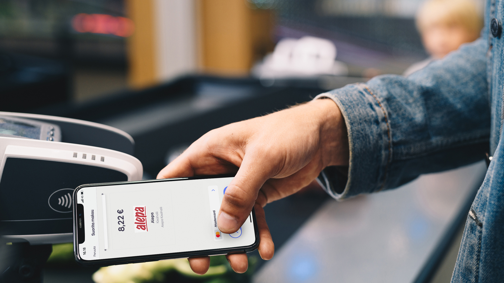 Mies maksaa ostoksistaan MobilePay sovelluksella maksupäätteella