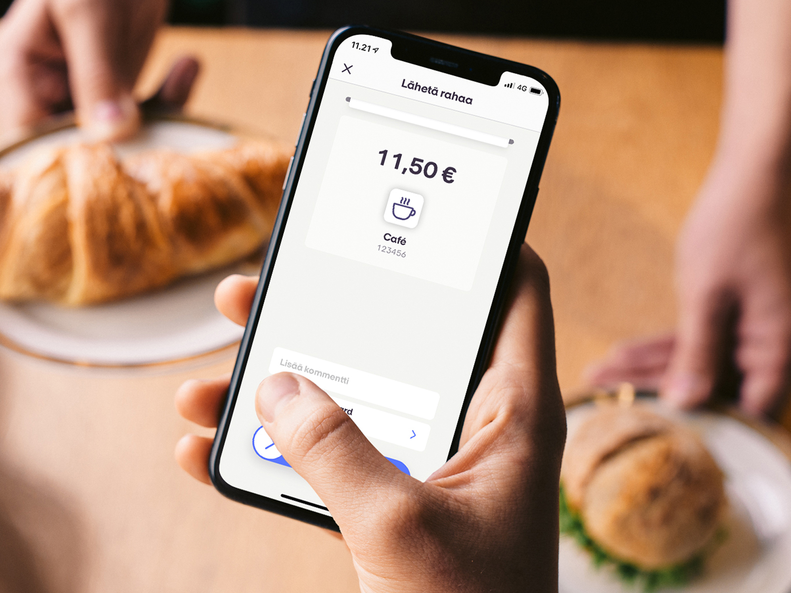 Ihminen kahvilan kassalla maksamassa MobilePay MyShopilla maksua ostoksista