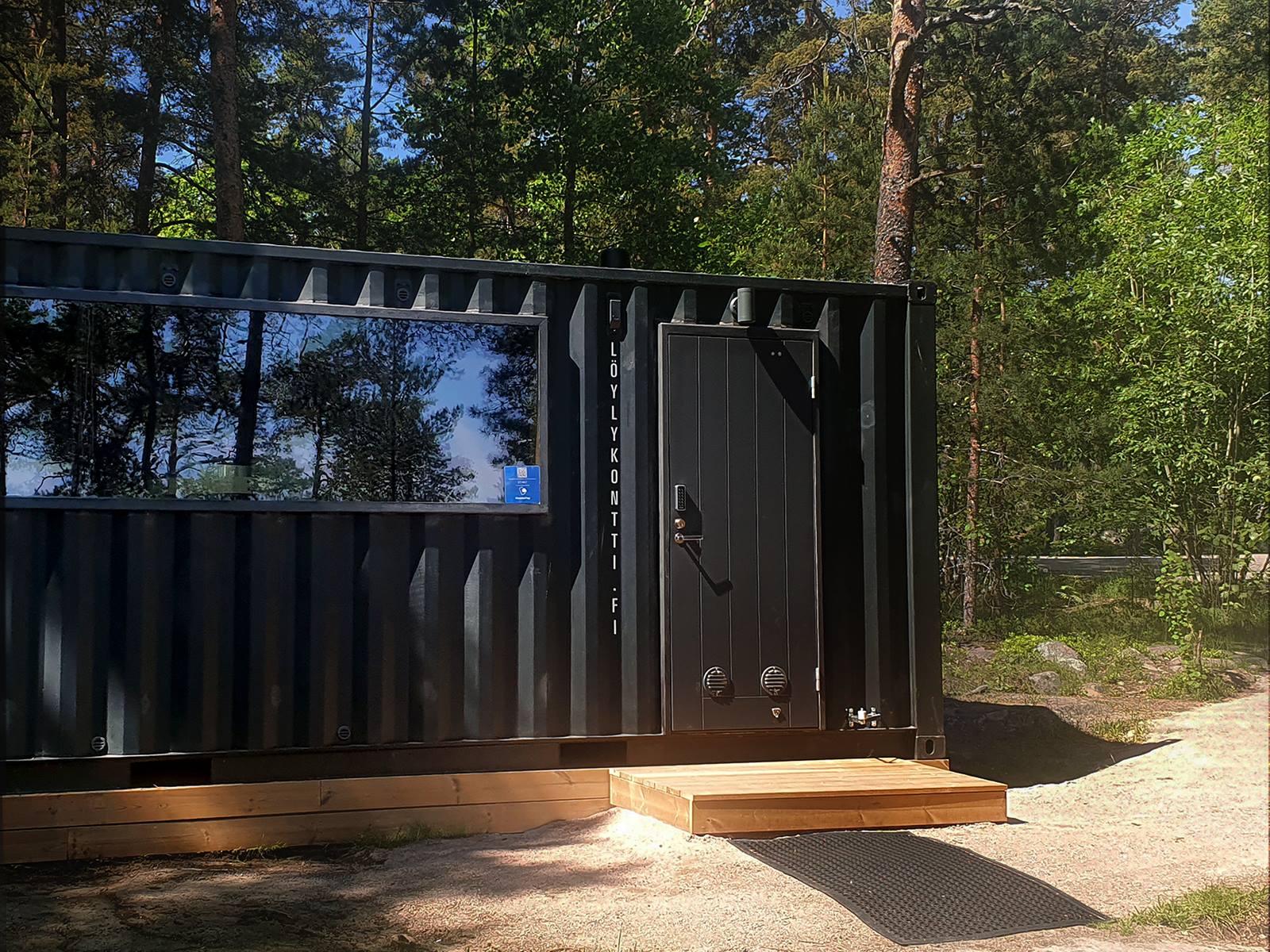 Löylykontti rannalla MobilePay-tarra ikkunassa