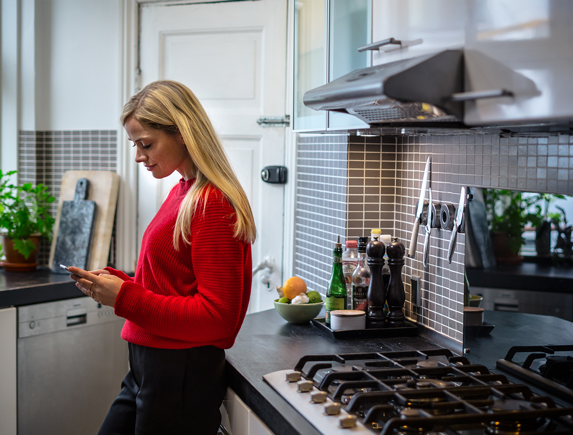 Woman using MobilePay in a kitchen.