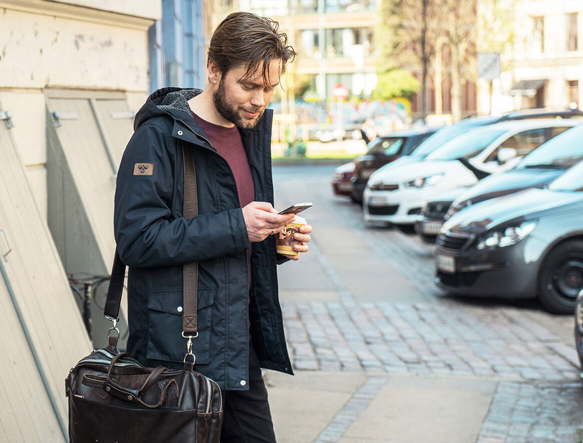 Nainen istumassa junassa ja lähetämmässä rahaa MobilePaylla